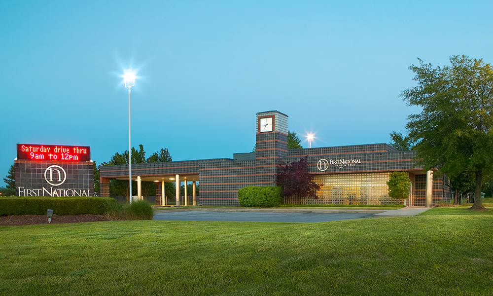 Exterior of First National Bank of Broken Arrow branch with clock tower and drive-thru.