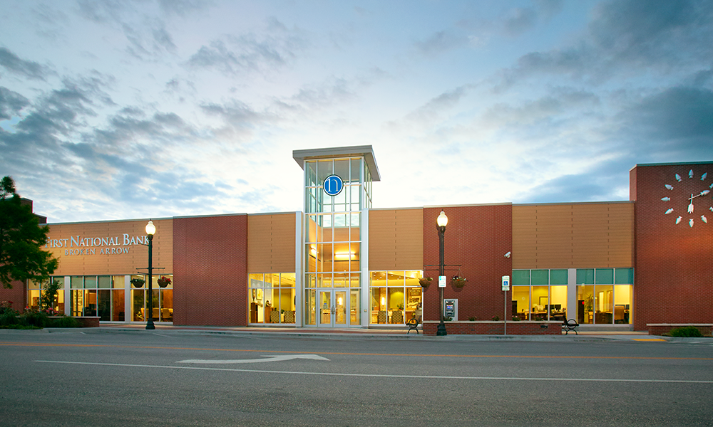 Exterior of First National Bank of Broken Arrow building at dusk.